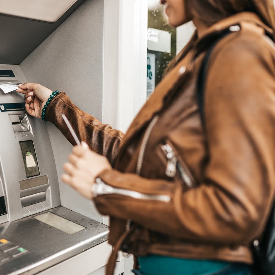 Lady getting money out of ATM.