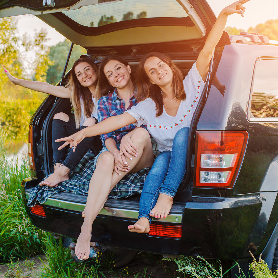 Young mom and daughters in back of car.